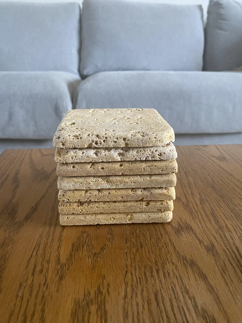 Stack of beige stone coasters with visible surface voids