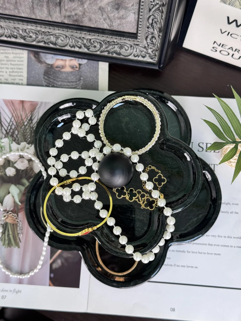 Two-tier green stone tray holding jewellery on a tabletop