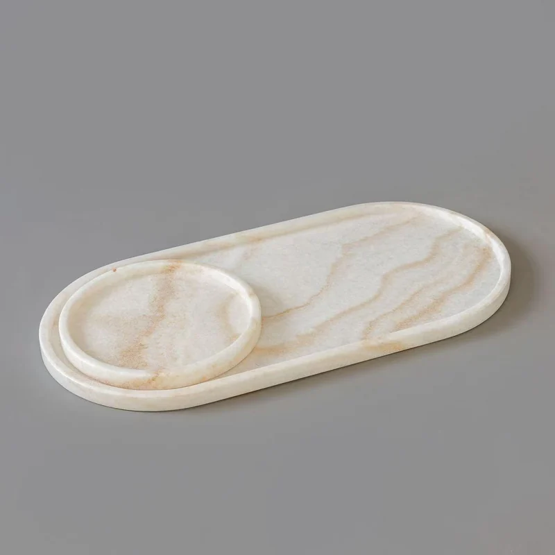 Pale oval stone tray and small dish arranged on a grey surface