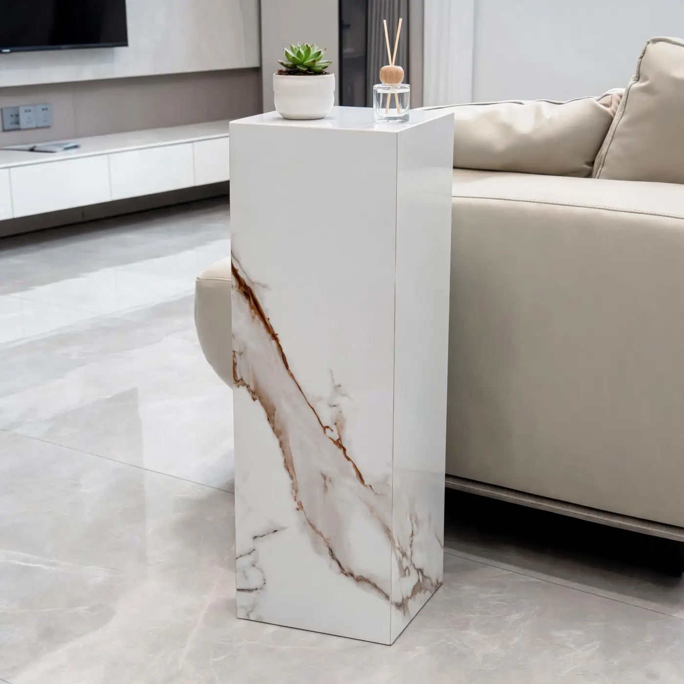 Calacatta Gold pedestal beside a light sofa